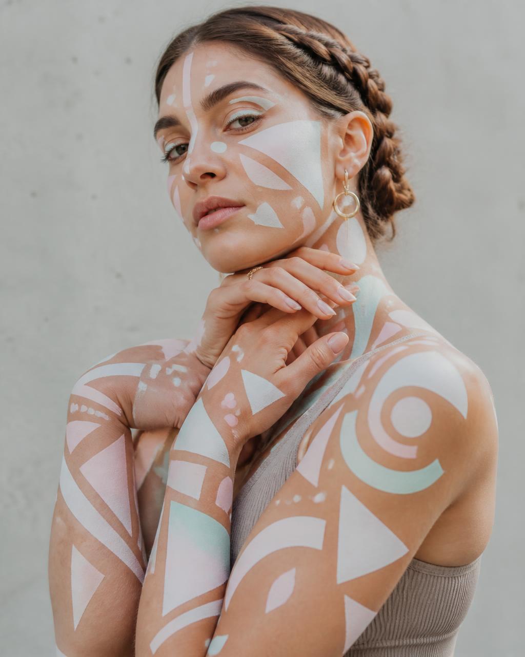 Festival body art in daylight, appearing as soft pastel geometric patterns